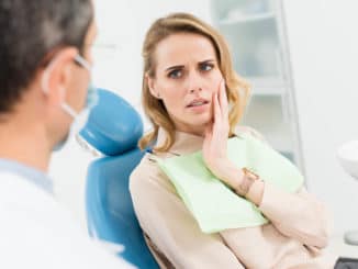 Frau mit Zahnschmerzen beim Zahnarzt